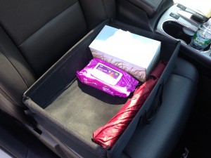 Use a car organizer with a rubber bottom and side handles to keep handy everything you need in the front of the car